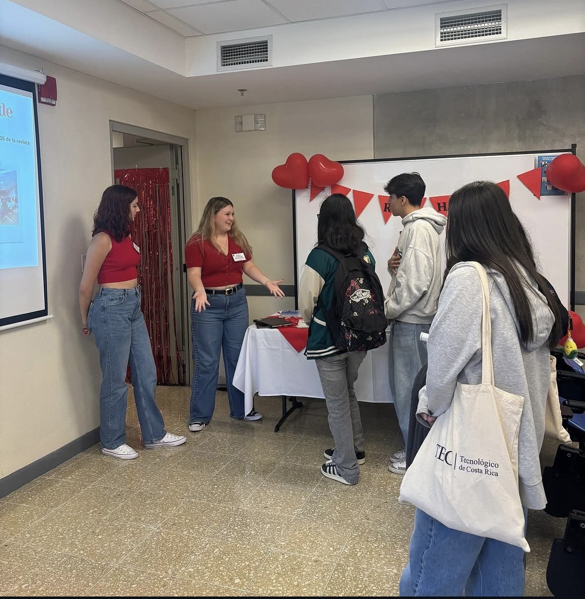 Miembros de la revista atendiendo a estudiantes en la feria institucional